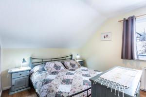 a bedroom with a bed and a desk and a window at Ferienwohnung Frankenblick in Frankenau