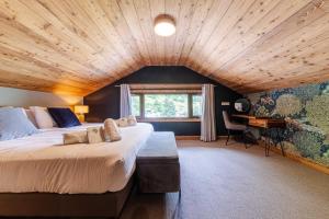 a bedroom with a large bed and a wooden ceiling at Hotel Du Lac in Montriond