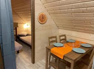 a wooden room with a table and a bed at Camping nature 3 étoiles avec piscine - bord de rivière in Chézery-Forens