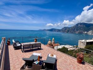 a patio with chairs and a view of the ocean at Villa Giardino Eden in Praiano