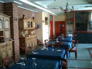 a dining room with blue tables and chairs in a room at Hotel VillaPaloma in La Virgen del Camino