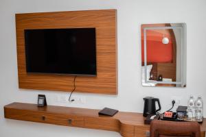 a flat screen tv mounted on a wall at GermanHomesHotel in Thimi +4 photos
