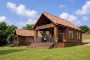 a small house with a roof on a grass field at Cabanas Allariz in Allariz