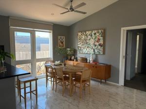 a living room with a dining room table and chairs at 10-Min Walk to Pearce Beach via Coastal Trail in Blairgowrie +29 photos