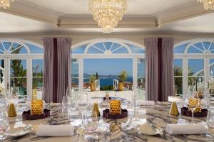 a dining room with a large table with a chandelier at Althoff Hotel Villa Belrose in Saint-Tropez