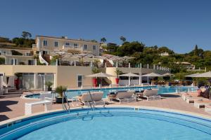 a large swimming pool with chairs and umbrellas at Althoff Hotel Villa Belrose in Saint-Tropez