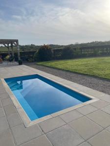 a small blue swimming pool on a patio at Umber, Gallery Cottages, Devon in West Putford