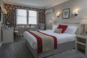 a hotel room with a large bed and a window at Birmingham North Moor Hall Hotel BW Premier Collection in Sutton Coldfield