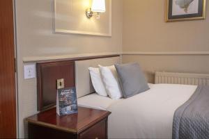 a hotel room with a bed and a wooden table at Birmingham North Moor Hall Hotel BW Premier Collection in Sutton Coldfield