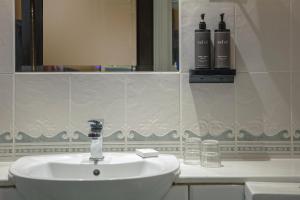 a bathroom with a sink and two bottles of shampoo at Birmingham North Moor Hall Hotel BW Premier Collection in Sutton Coldfield +58 photos