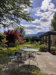 a picnic table and chairs in a garden at Le Temps d'une Pause in Andert-et-Condon