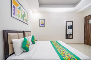 a bedroom with a bed with green and yellow pillows at Treebo Modern Stays in Noida