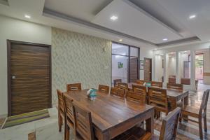a dining room with a large wooden table and chairs at Treebo Modern Stays in Noida