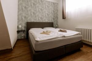 a bedroom with a bed with two towels on it at Hotel Ratsstuben Kalbe in Kalbe
