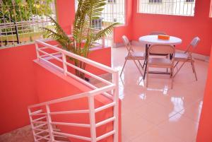 a table and chairs in a room with red walls at Cedar Grove Luxe in Portmore