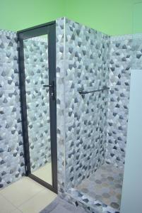 a shower with a glass door in a bathroom at Cedar Grove Luxe in Portmore +25 photos