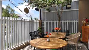 a patio with two tables and chairs and a fence at NEST House in Ấp Kim Thạch