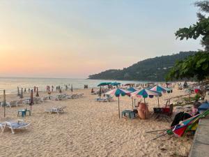 a beach with a lot of chairs and umbrellas at Tony Home and Restaurant in Karon Beach