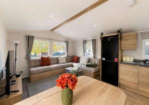 a kitchen and a living room with a table at Kestrel Court 16 in Scratby