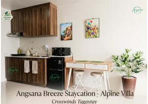 a kitchen with a black refrigerator and a counter with stools at Angsana Breeze-Alpine Crosswinds Tagaytay in Ulot