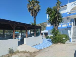 a building with palm trees in front of it at Jack's Apartments in Kefalos