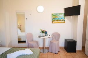 a room with a table and chairs and a bedroom at Hotel Sorriso in Brenzone sul Garda