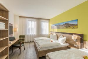 um quarto de hotel com duas camas, uma secretária e um computador em Sleepin Premium Motel Loosdorf em Loosdorf