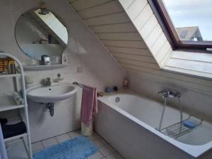 a bathroom with a sink and a tub and a mirror at Drachenfels Nest in Königswinter