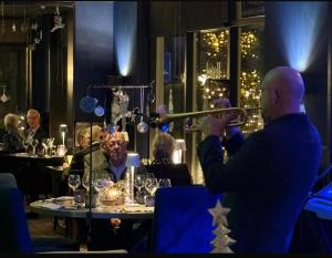 een man die fluit speelt aan een tafel in een restaurant bij Hotel Wapen van Delden in Delden +83 foto's