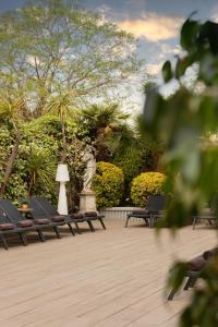 a park with chairs and a statue and trees at Augusta Club & Spa - Adults Only in Lloret de Mar