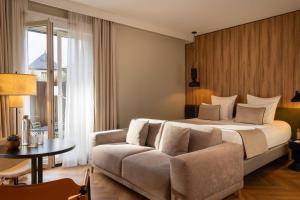 a hotel room with a bed and a couch at Le Richebourg Hôtel, Restaurant & Spa in Vosne-Romanée +70 photos