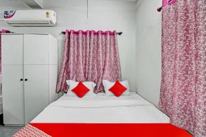 a bed with red pillows in a room at Hotel O Moonlight Inn in Nagpur