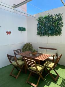 a wooden table with two chairs and a butterfly on the wall at Tabano in Chipiona