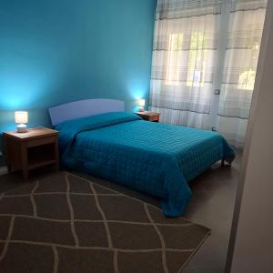 a blue bedroom with a bed and two night stands at Quasi in Cattedrale, nel cuore storico di Asti in Asti