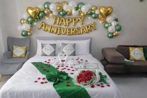 a bedroom with a bed with a happy anniversary sign on the wall at Angsana Breeze-Alpine Crosswinds Tagaytay in Ulot +99 photos