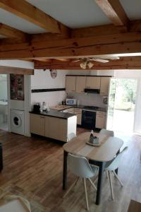 a kitchen with a table and chairs in a room at Le roqual in Carsac-Aillac