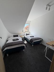 two beds sitting in a room with a window at Pensjonat Resident in Krynica Morska
