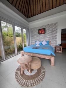 a bedroom with a blue bed and a stool at The Breezy Volcano in Kintamani