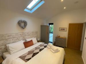 a bedroom with a bed with a heart plaque on the wall at Umber, Gallery Cottages, Devon in West Putford +11 photos