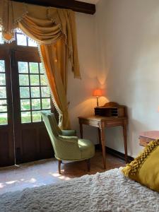 a bedroom with a bed and a desk and a chair at Domaine Lainault - Chambre Jasnières in Lhomme