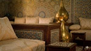 a bedroom with a bed and a lamp and a couch at Villa Majlis in Marrakesh