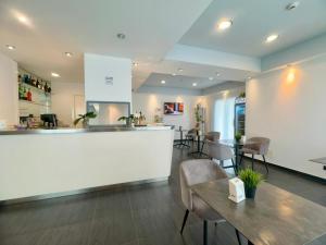a restaurant with a counter and tables and chairs at Maestrale Resort Hotel - Grosseto in Grosseto