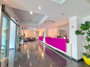 an office lobby with a pink reception desk at Maestrale Resort Hotel - Grosseto in Grosseto