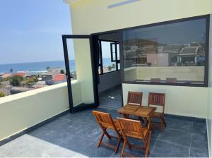 a patio with two chairs and a table on a balcony at Khách Sạn View Biển - Homestay Sân Vườn - QUANG VINH Đảo Lý Sơn -Vị Trí Trung Tâm Đảo - Cạnh Bến cảng và Quảng trường in Ly Son