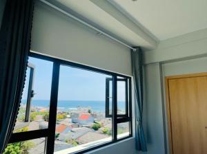 a room with a window with a view at Khách Sạn View Biển - Homestay Sân Vườn - QUANG VINH Đảo Lý Sơn -Vị Trí Trung Tâm Đảo - Cạnh Bến cảng và Quảng trường in Ly Son +10 photos