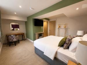 a bedroom with a bed and a desk and a television at The Old Malthouse Caerleon in Caerleon