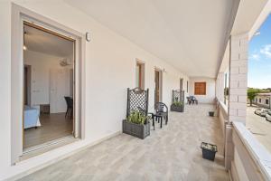 a large balcony with a view of a room at CLASS ROOMS AFFITTACAMERE con bagno privato , vicino alle DUNE di PORTO PINO in SantʼAnna Arresi +51 photos