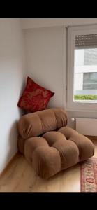 a brown ottoman in a room with a window at Studio chic et élégant avec Wi-Fi et Smart TV in Lausanne