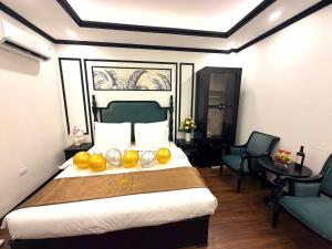 a hotel room with a large bed with fruit on it at Green Luxury Hanoi Hotel in Hanoi