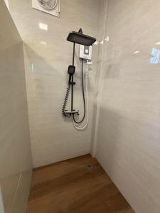 a shower in a room with a phone on the wall at KaizaHotel Suvarnabhumi Airport in Lat Krabang